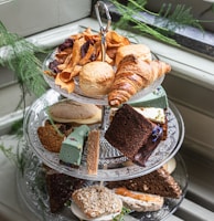 a three tiered tray of food on a window sill