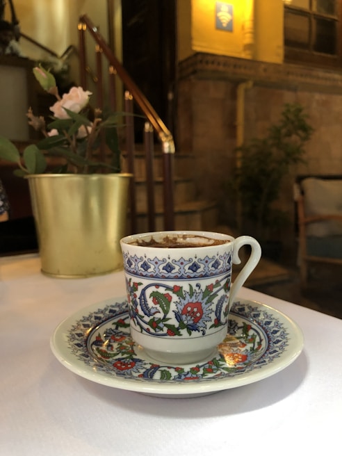 Design Cup with a vibrant floral pattern, showcasing its sleek stainless steel finish on a soft pastel background