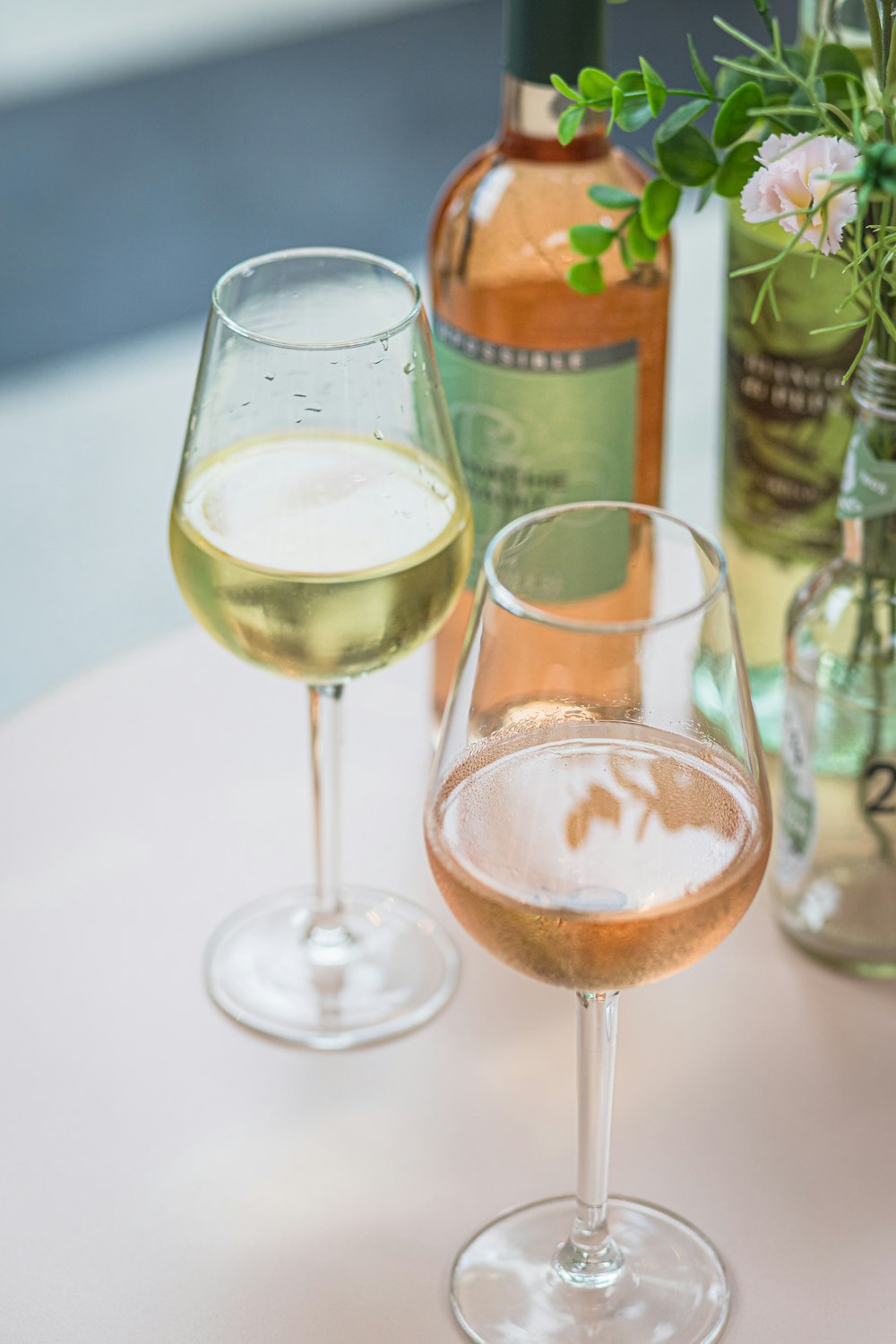 Dos copas de vino y una botella de vino sobre una mesa