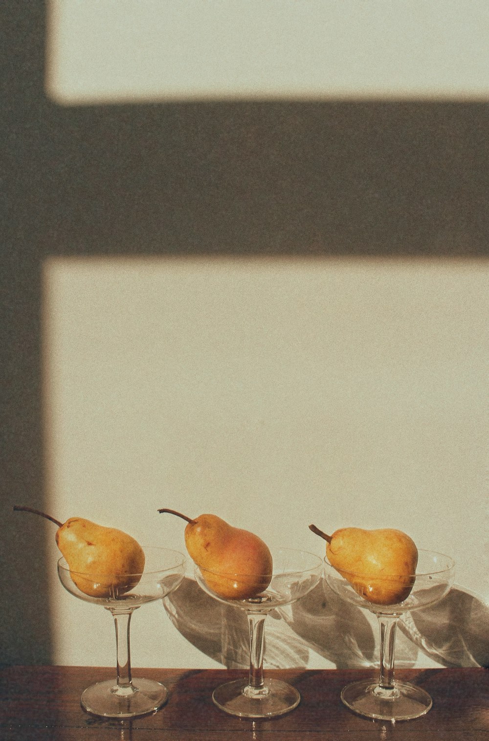 a row of wine glasses with pears in them