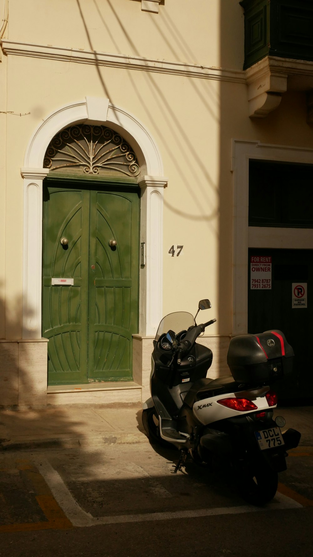 uma motocicleta estacionada na frente de uma porta verde