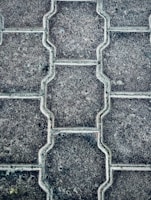 Close-up of freshly laid interlock paving with precise patterns in a residential driveway.