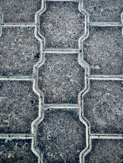Close-up of freshly installed pavers forming a neat patio under warm sunlight.