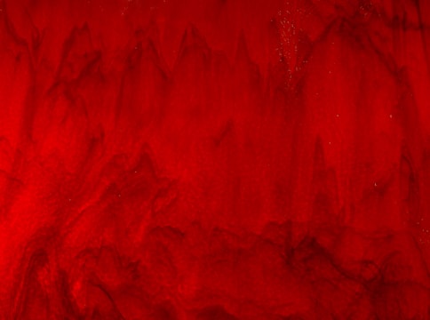 A textured red background with various shades and subtle patterns resembling waves or flames, giving a sense of movement and depth.