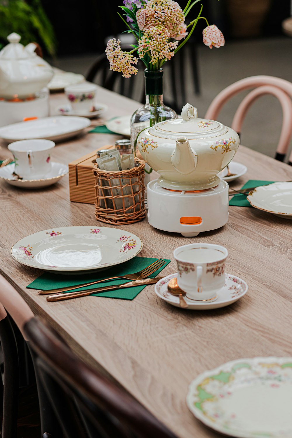 a wooden table topped with plates and cups