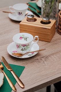 A table setting featuring vintage china, soft pastel napkins, and gold flatware.