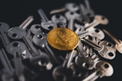 A golden Bitcoin coin is centered among a pile of metallic keys, symbolizing digital security and financial access.