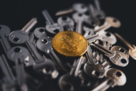 A golden Bitcoin coin is centered among a pile of metallic keys, symbolizing digital security and financial access.