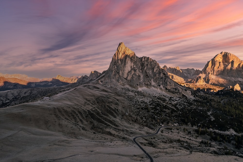 a mountain range with a winding road in the foreground