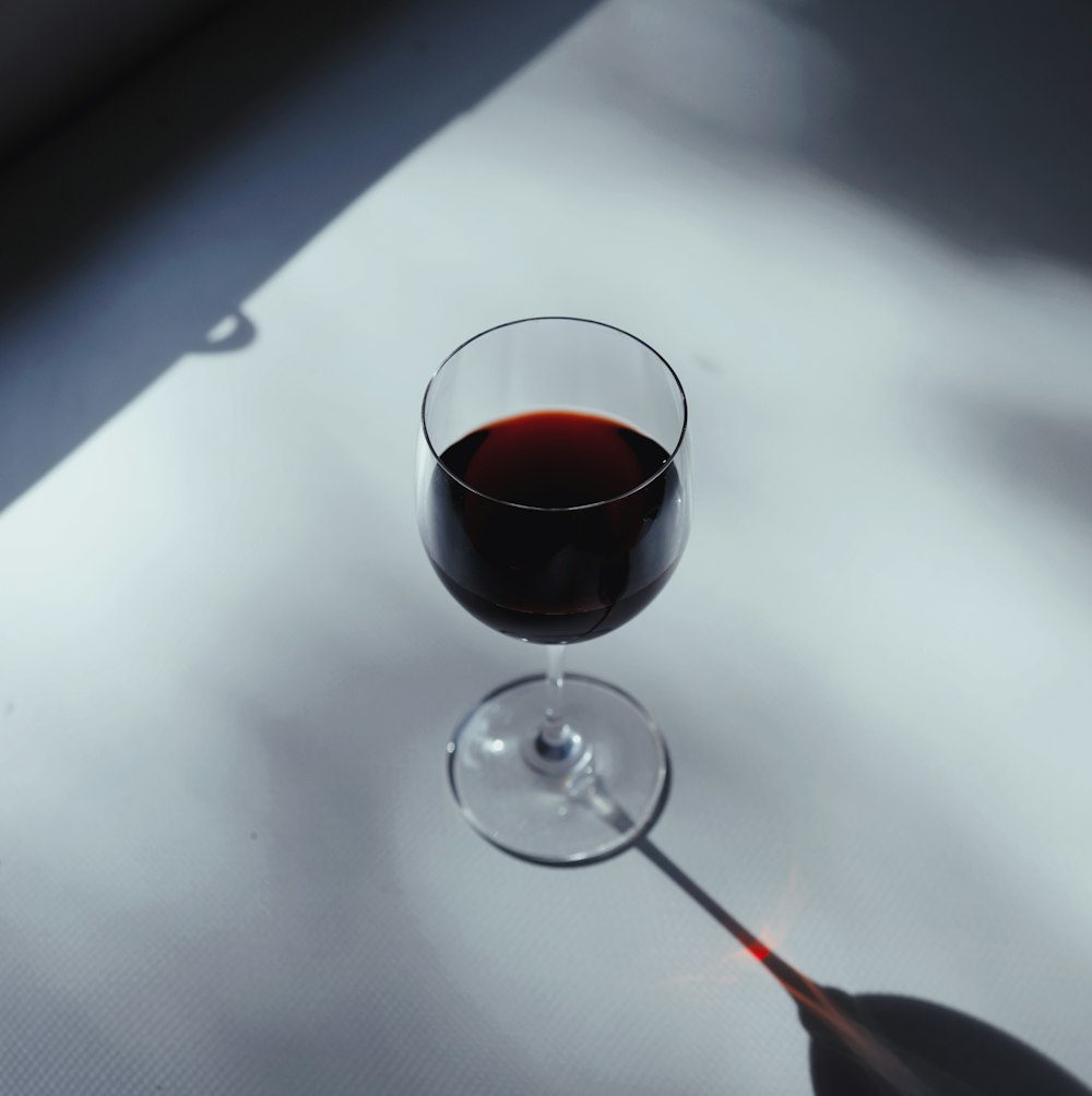 a glass of wine sitting on top of a table