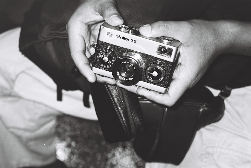 a black and white photo of a person holding a camera