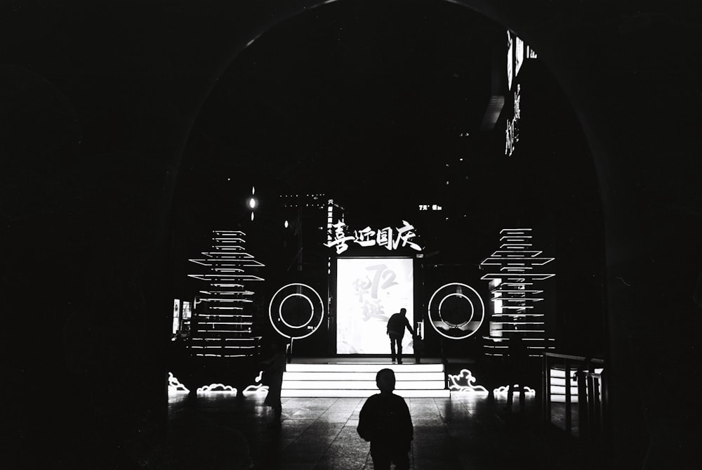 a black and white photo of a person standing on a stage