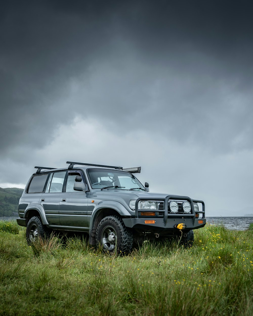 a vehicle parked in a field with a dark sky in the background