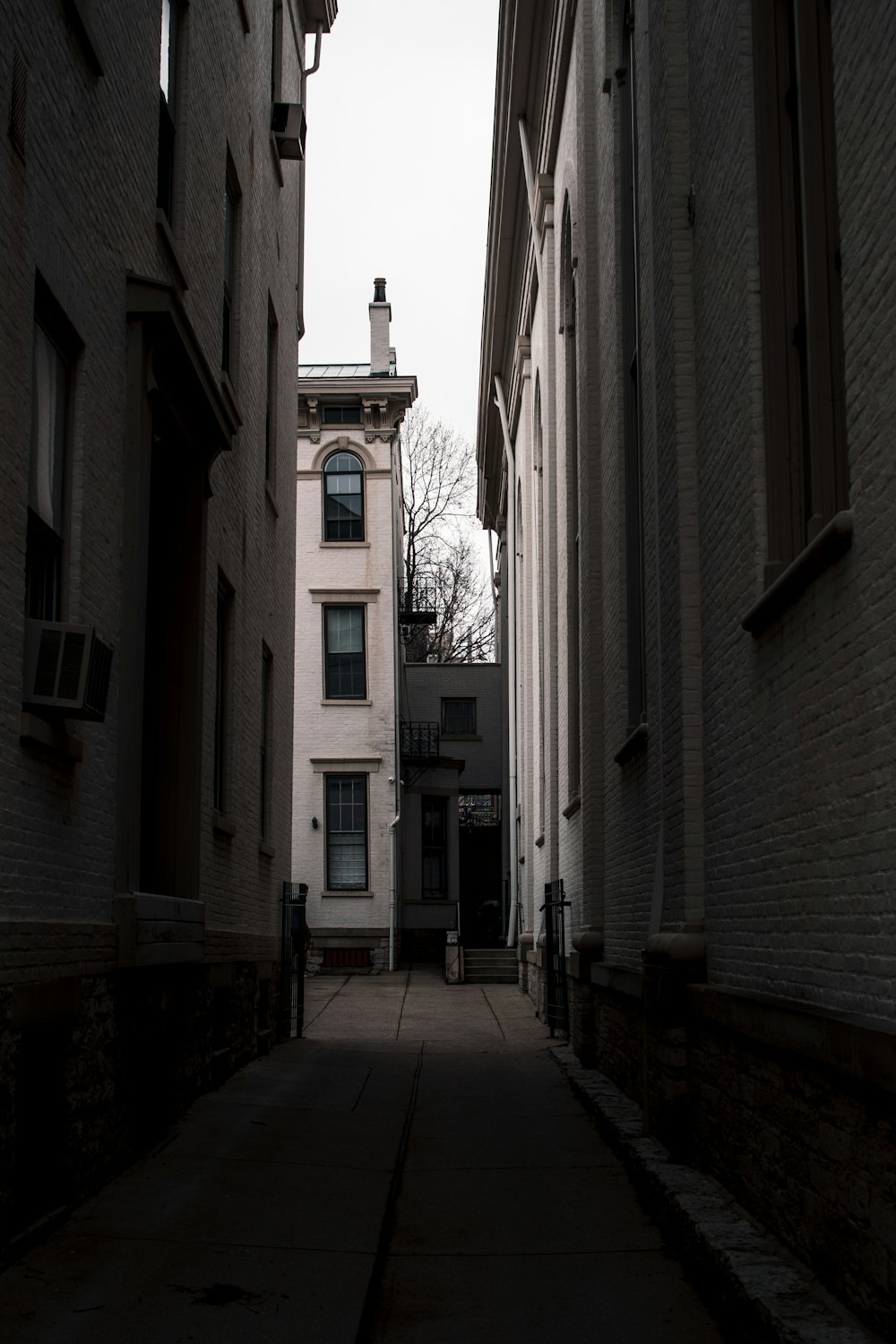 a narrow alley way with a clock tower in the distance