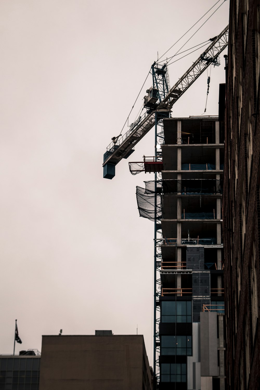 a crane on top of a building next to a tall building