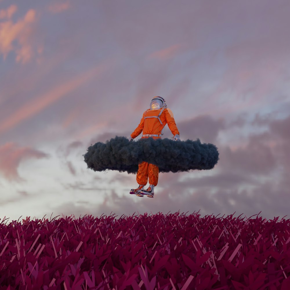 um homem em um terno laranja está flutuando no ar