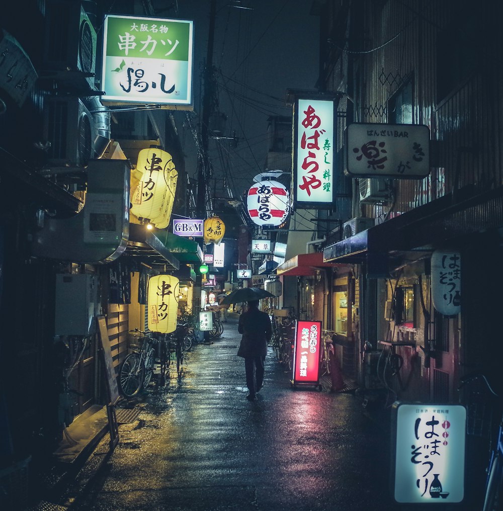 a person walking down a street at night