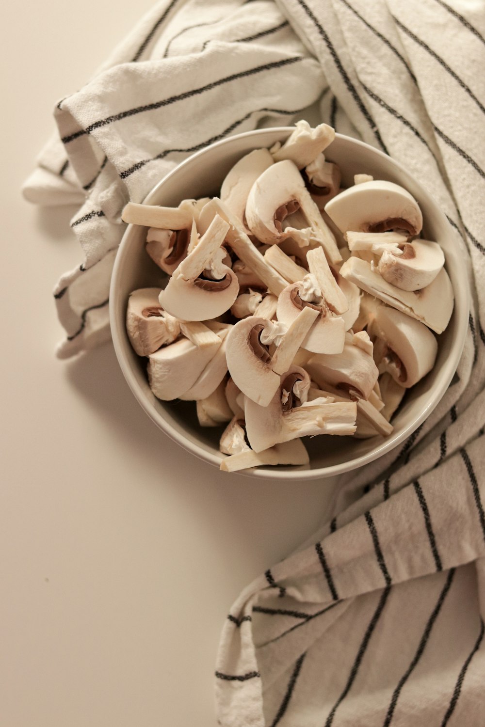 a bowl filled with sliced mushrooms on top of a table