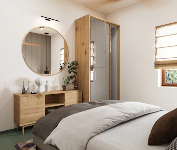 A modern bedroom with minimalist decor, featuring a large round mirror above a wooden dresser with various decorative vases. The bed is neatly made with layered bedding in neutral tones. A potted plant adds a touch of greenery beside the dresser. There are cream-colored Roman shades covering a window, allowing natural light to enter the room.