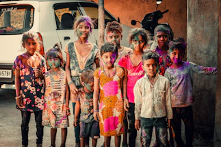 a group of children standing in front of a van