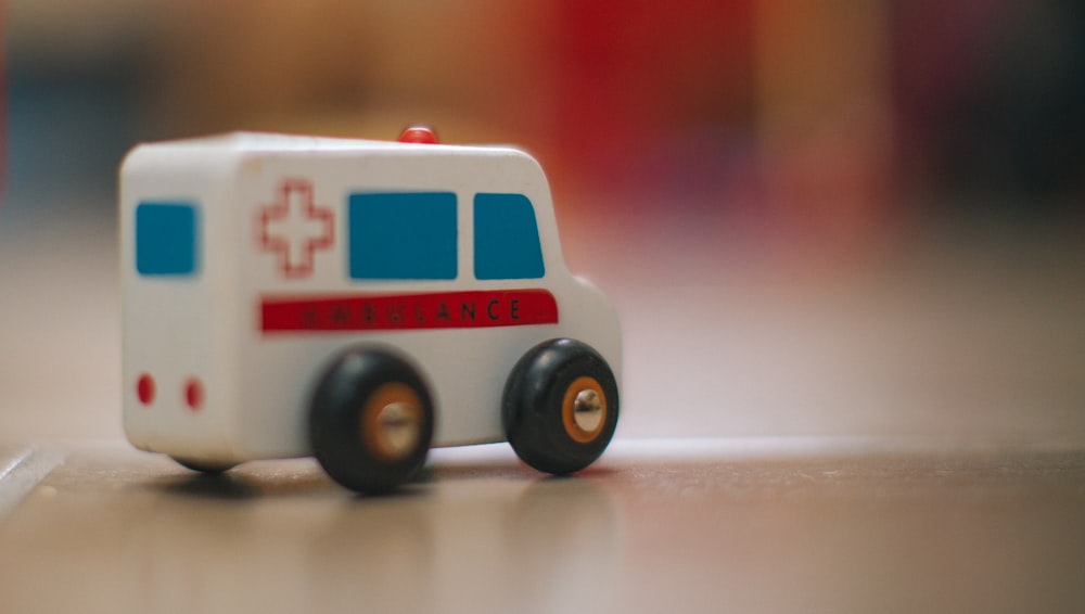 uma ambulância de brinquedo está sentada no chão