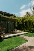 a patio with a table and chairs in the grass