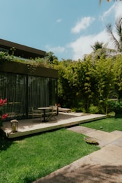 a patio with a table and chairs in the grass