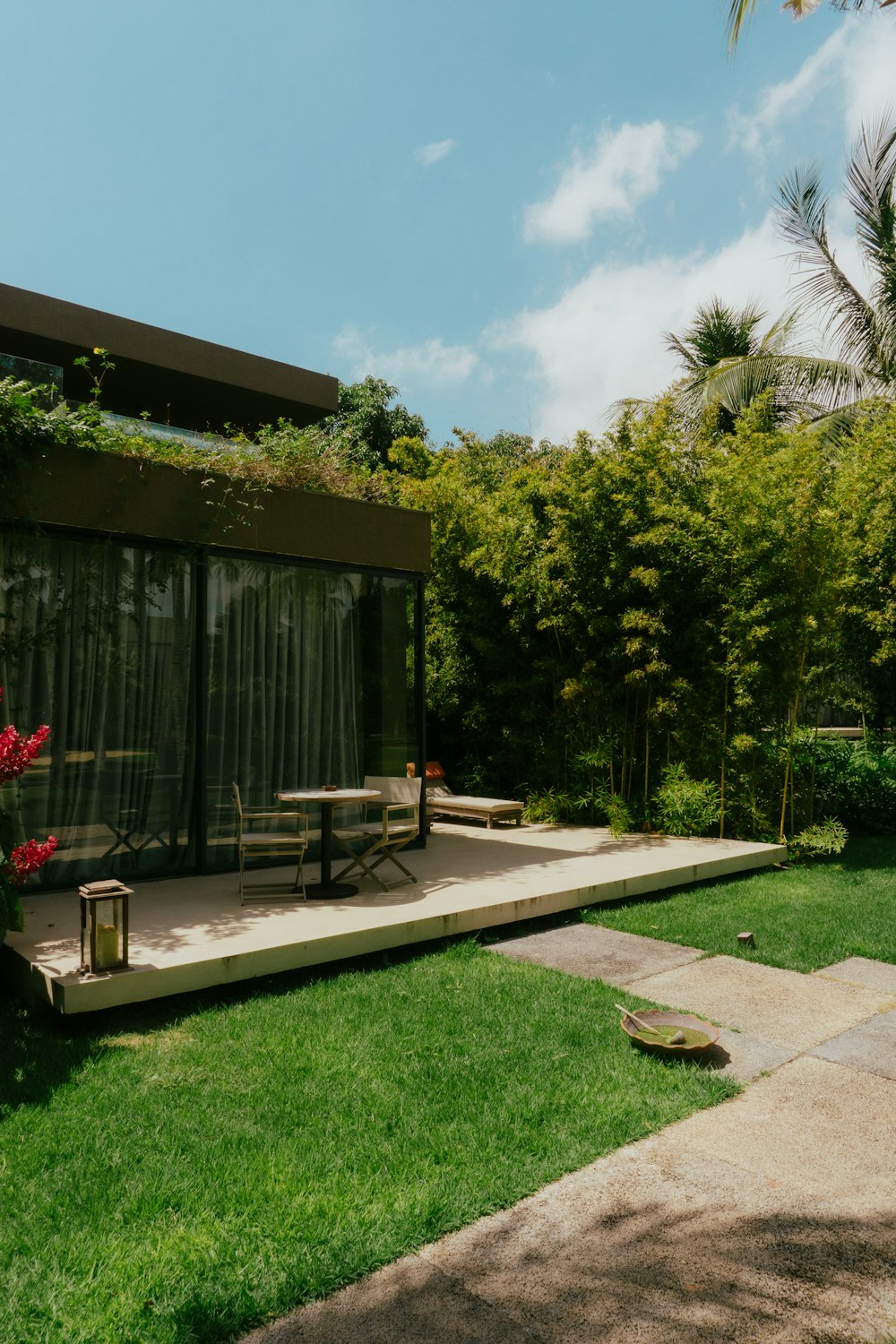 a patio with a table and chairs in the grass