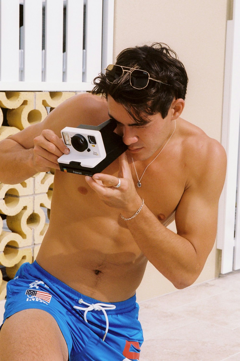 a shirtless man taking a picture with a camera