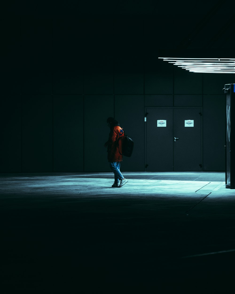 a person in a dark room with a backpack