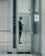 a man in a suit is looking at his cell phone