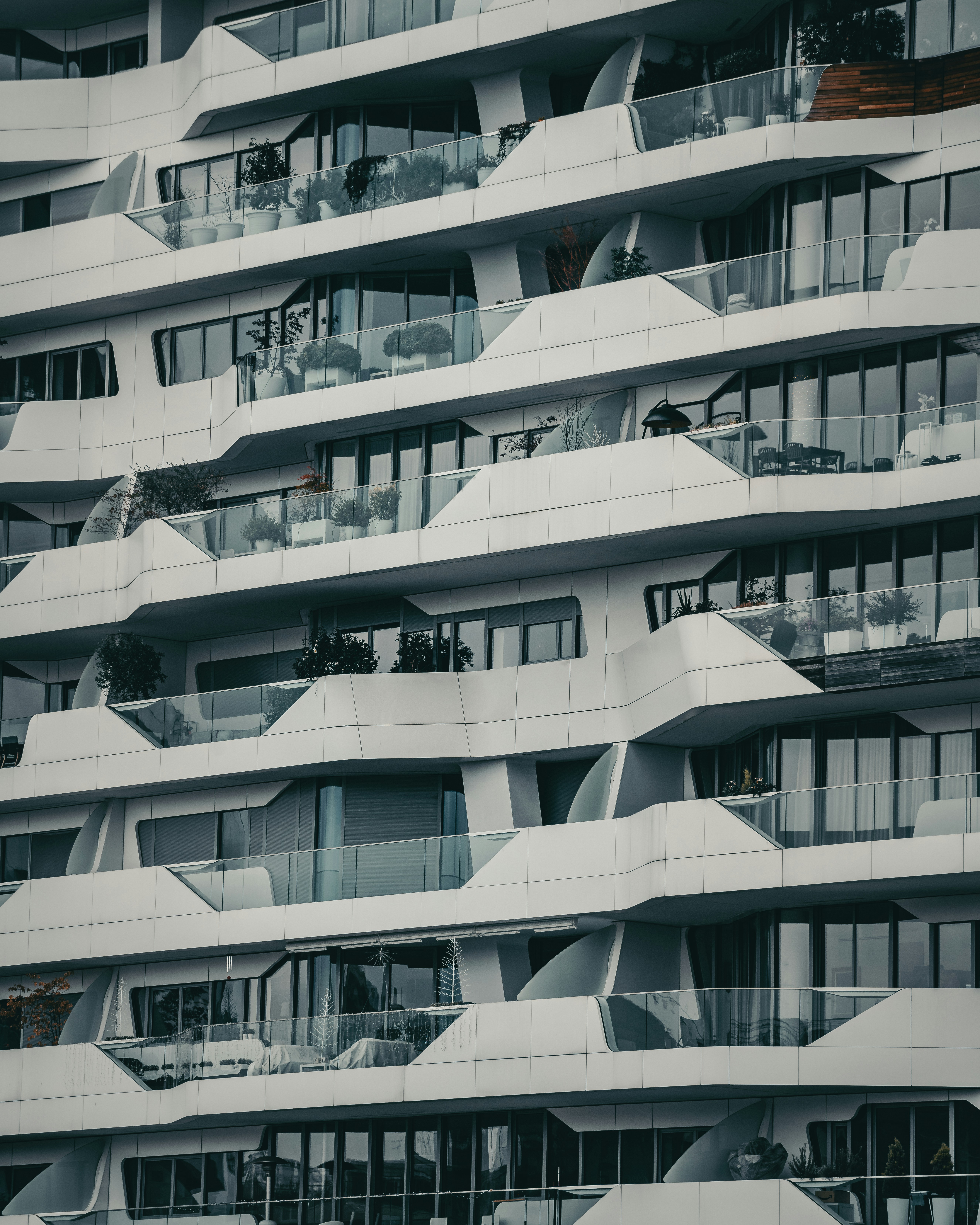 Modern apartment building with white curvilinear architecture and glass balconies.