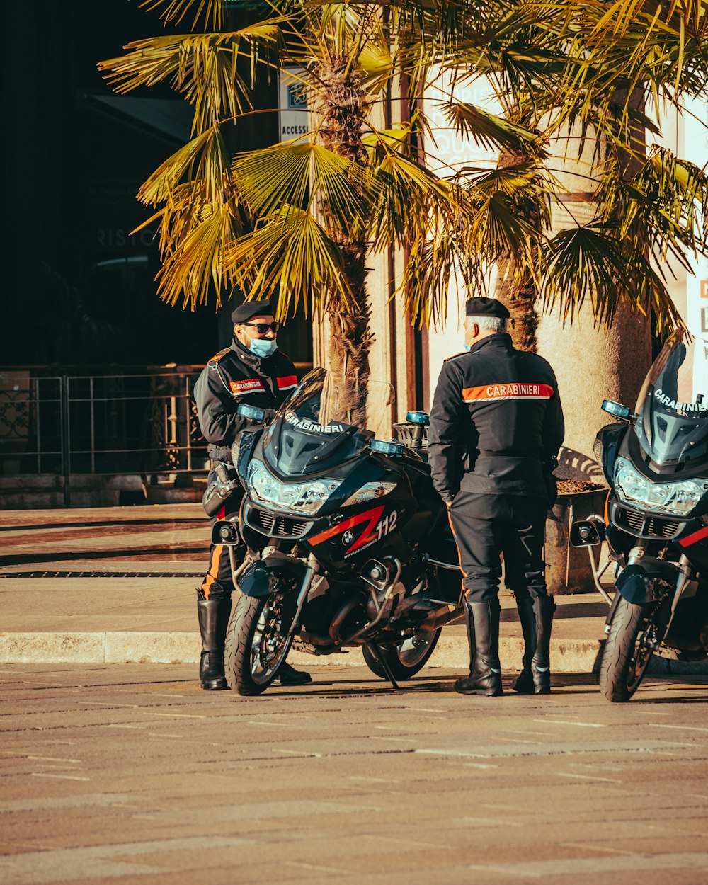 a couple of men standing next to motorcycles