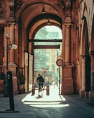 a man riding a bike down a street next to a tall building