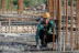 Portrait of a smiling middle-aged man in a construction helmet standing at a building site.