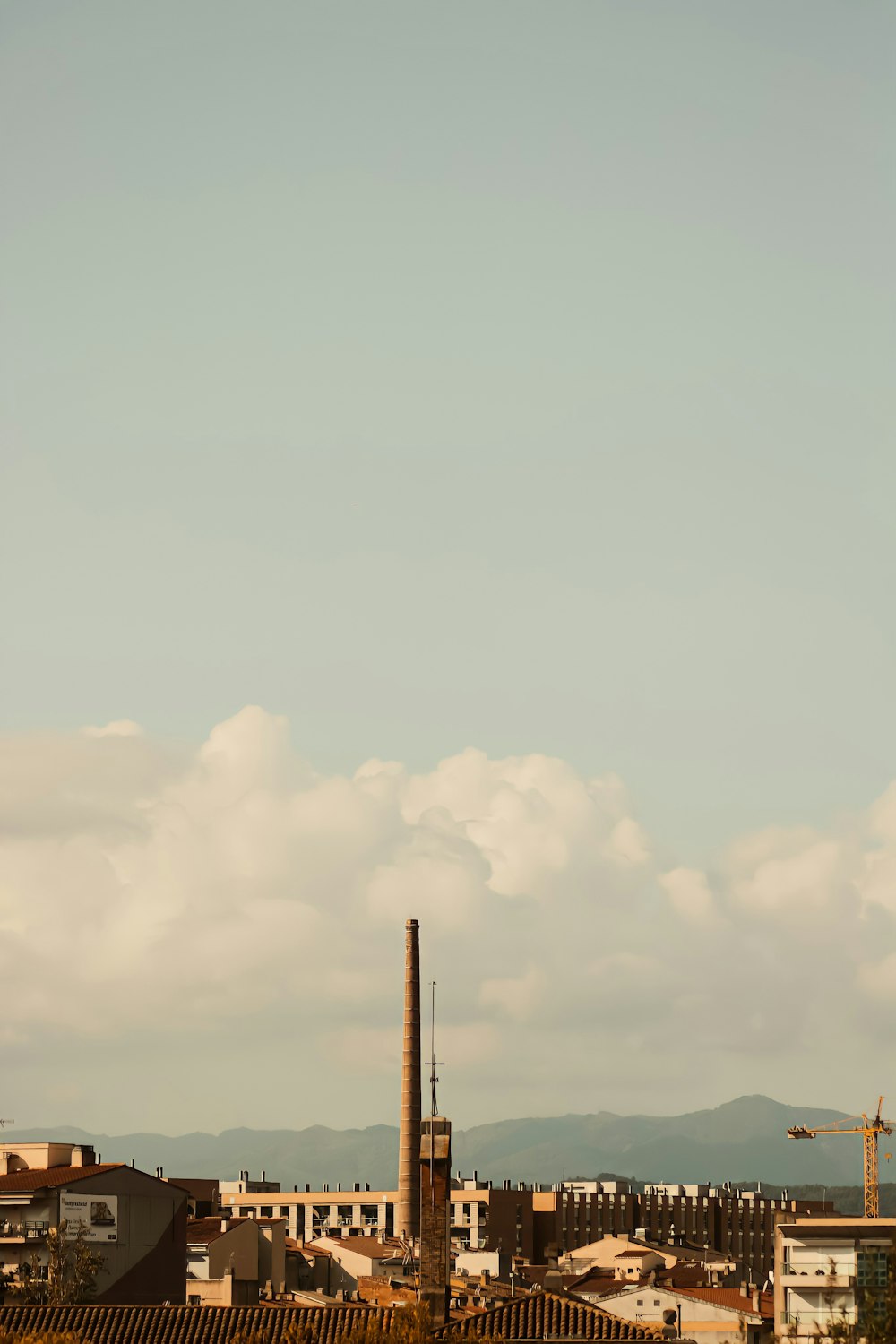 a view of a city with a tower and mountains in the background