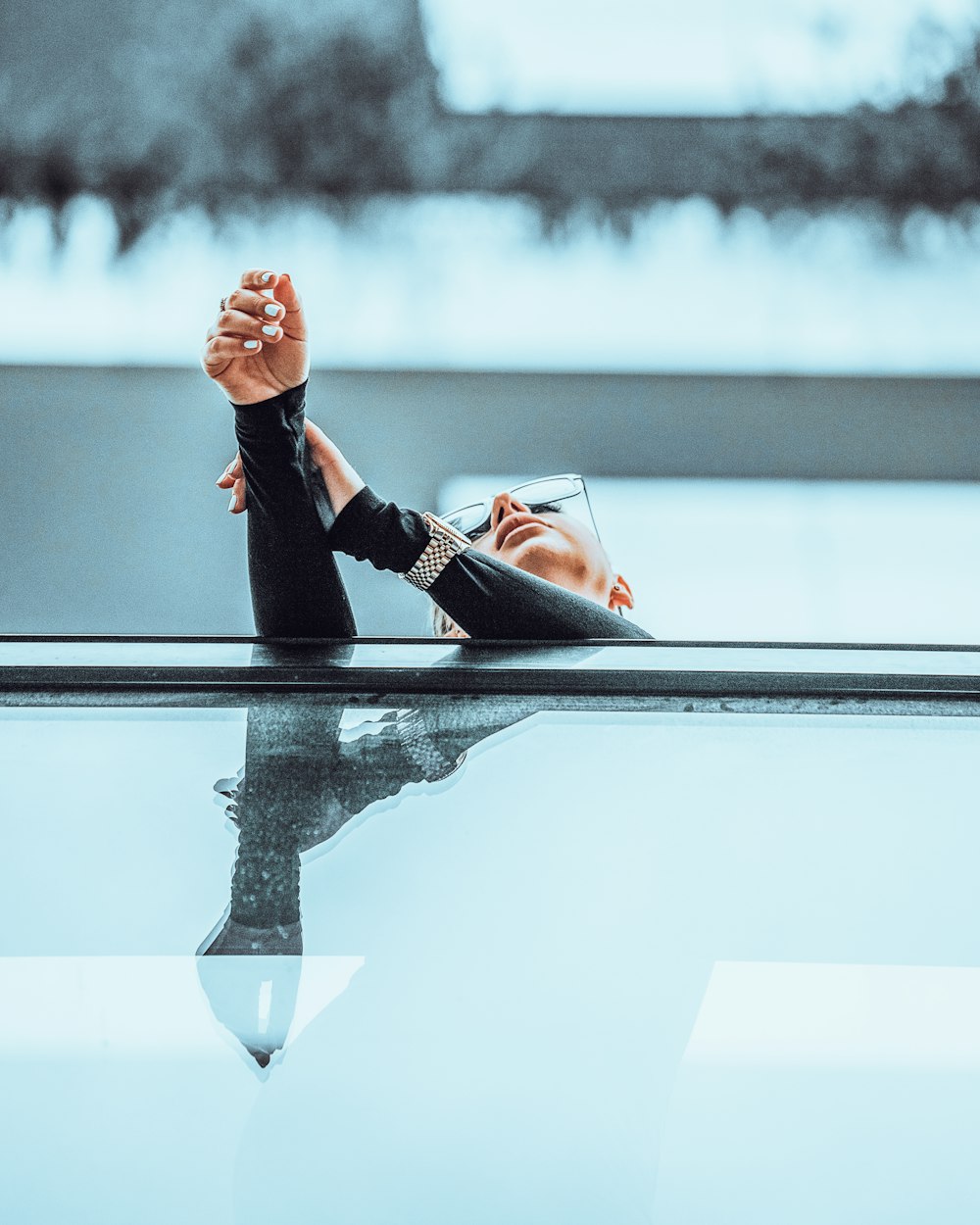 los pies de una mujer descansando sobre una superficie brillante