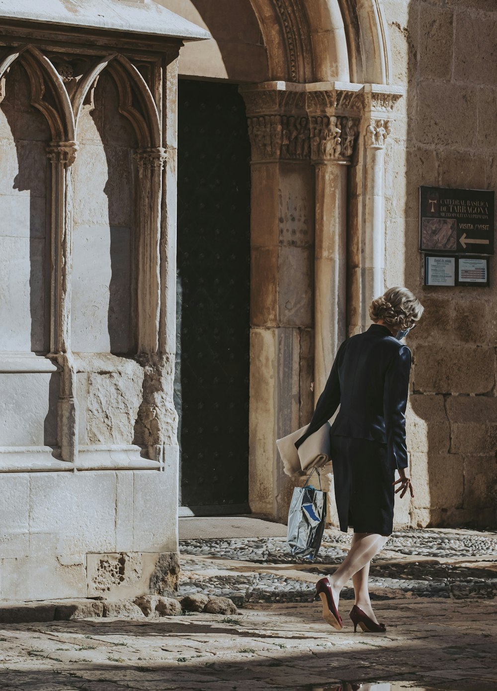 a woman walking down the street carrying a bag