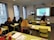 A diverse group of students engaged in an online class, with a teacher visible on a screen.