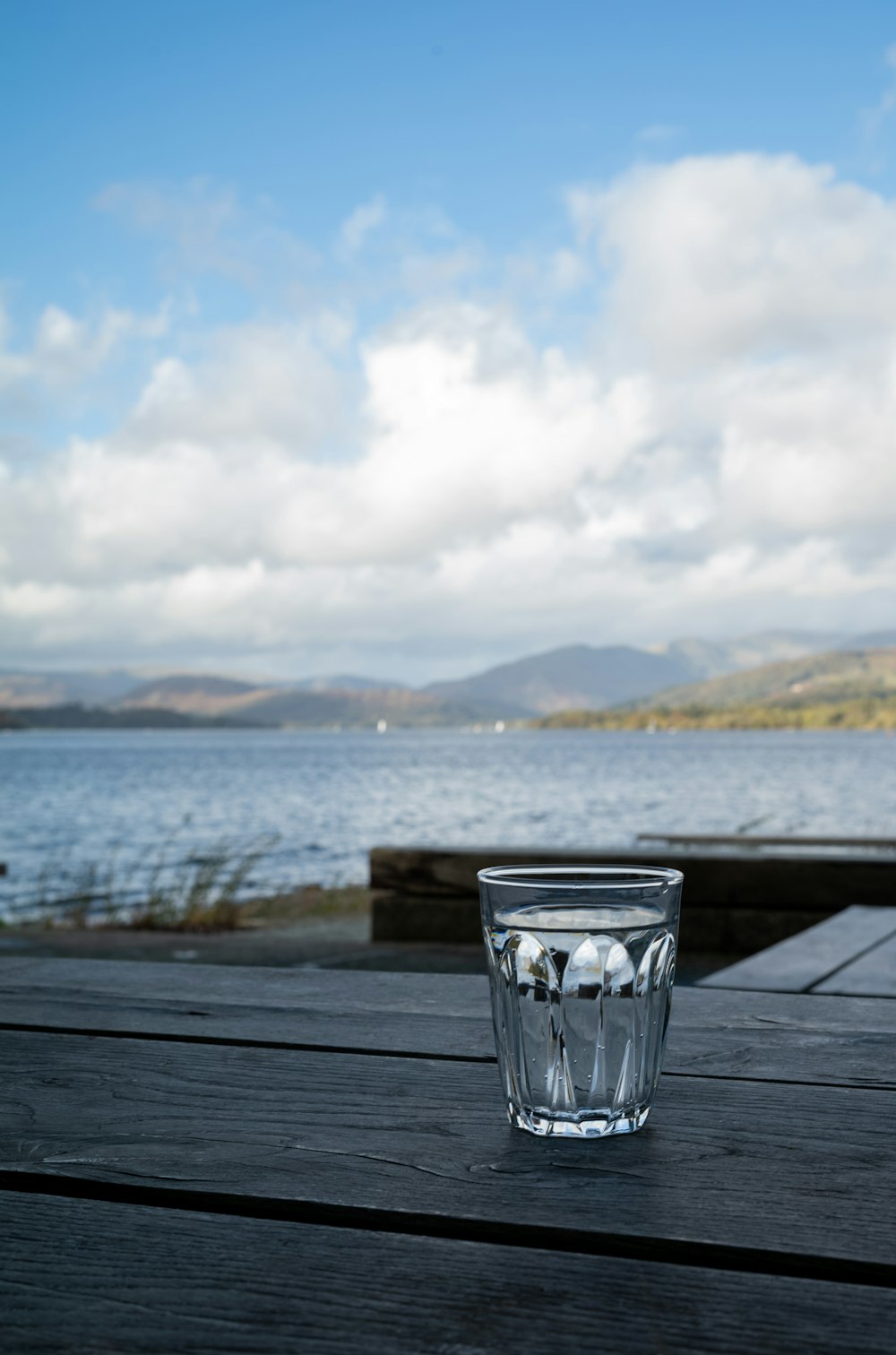 un bicchiere d'acqua seduto sopra un tavolo di legno