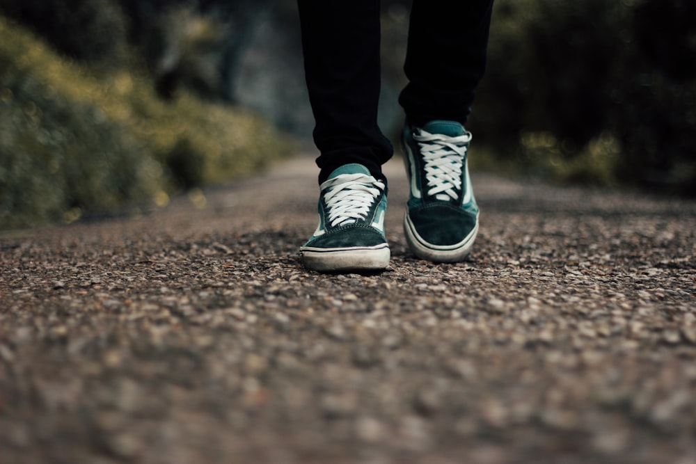 a person standing on a gravel road with their shoes on