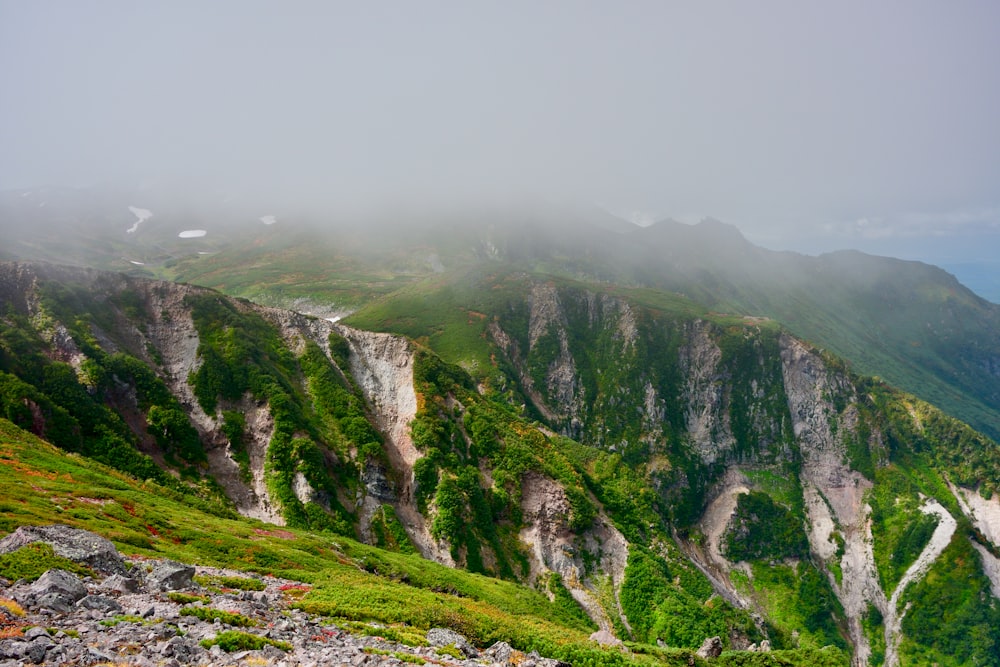 a scenic view of a mountain range with a foggy sky