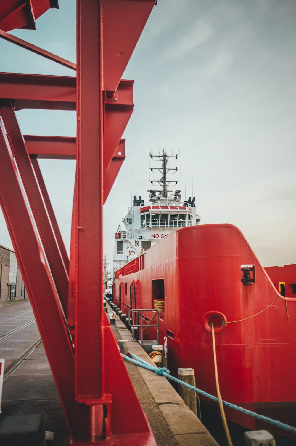 a large red boat sitting next to a dock