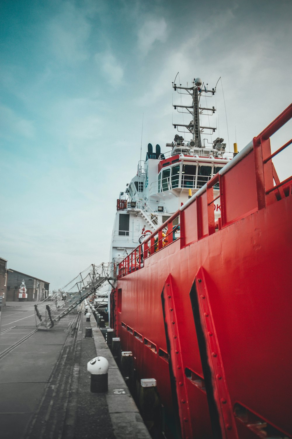 a large red boat sitting next to a dock