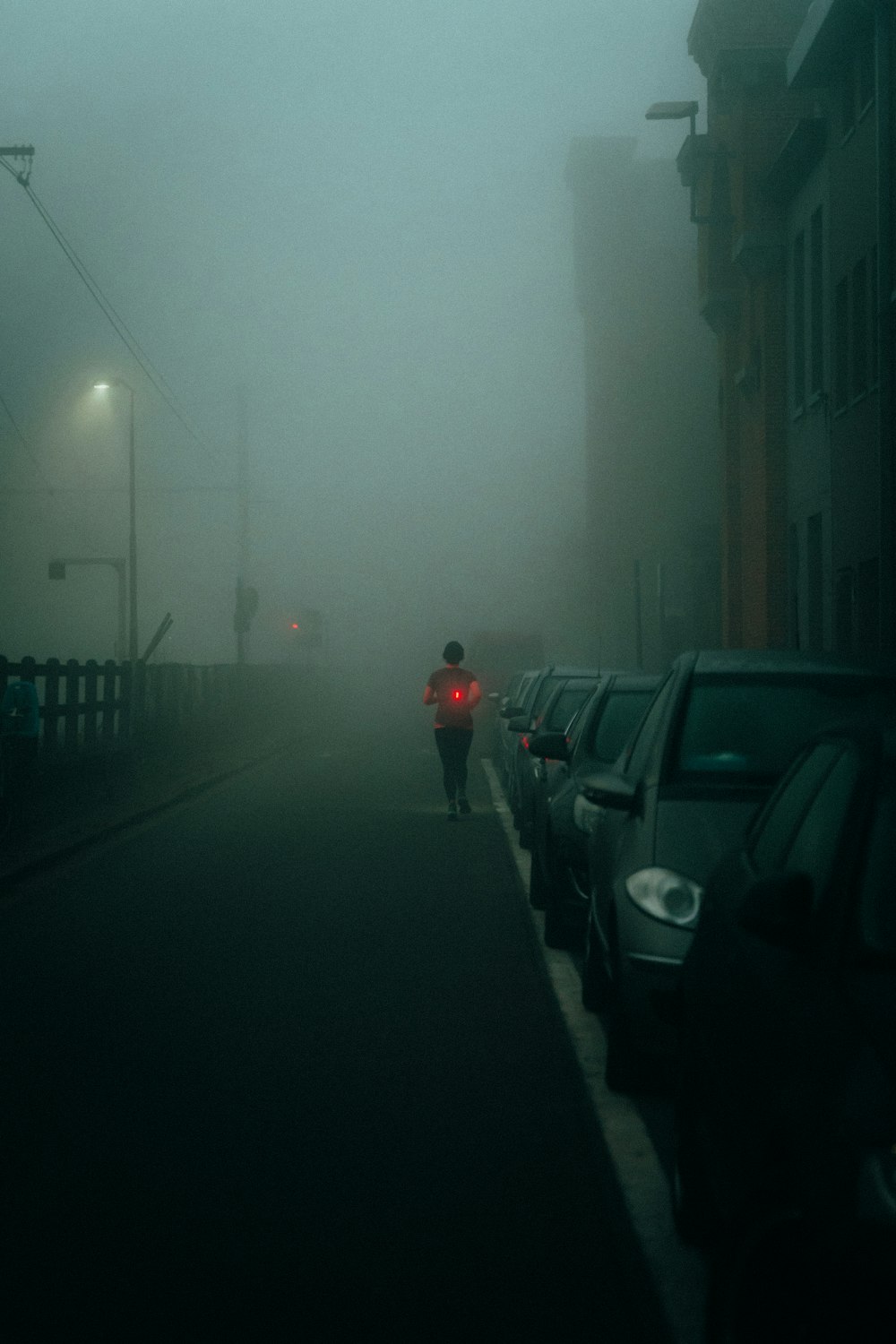 a person walking down a street in the fog