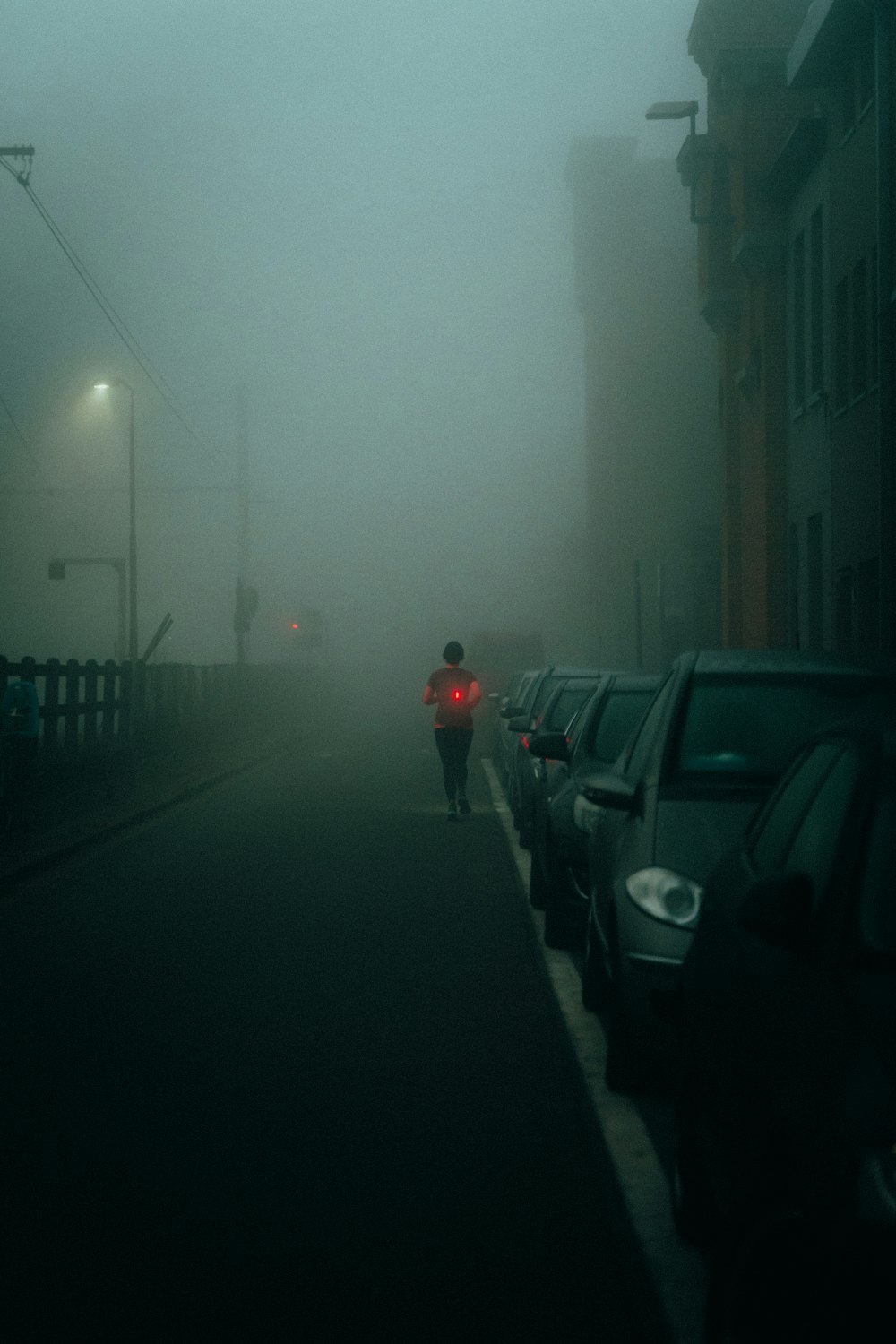 Una persona che cammina lungo una strada nella nebbia