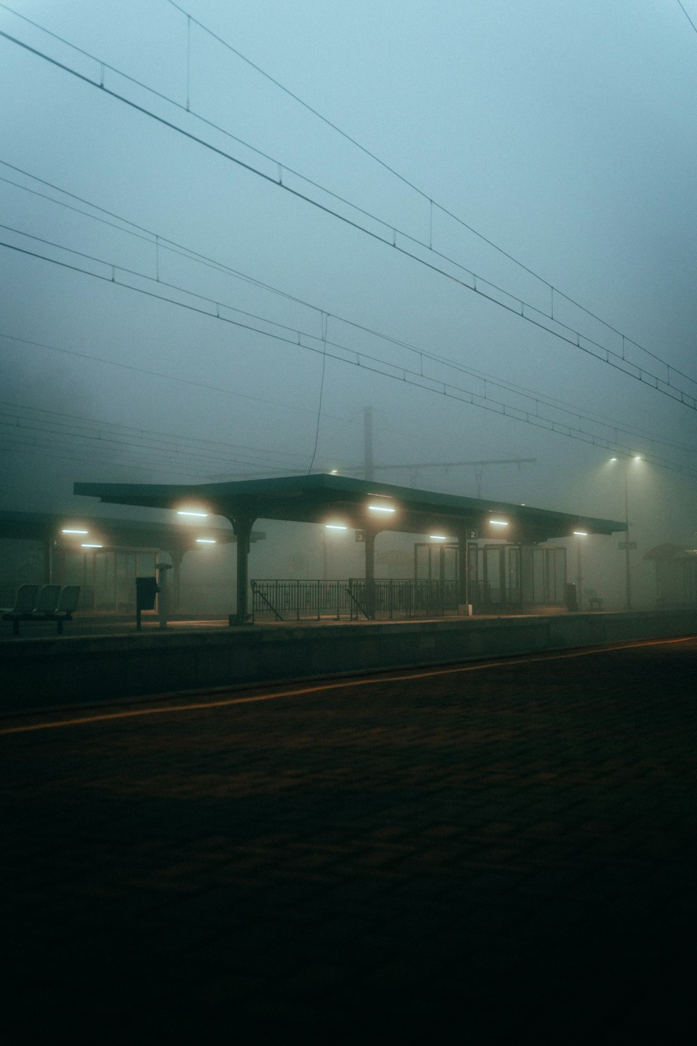 a foggy train station with a train on the tracks