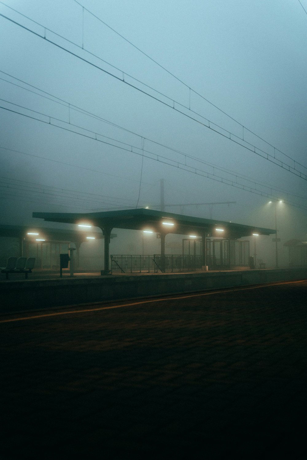 Una stazione ferroviaria nebbiosa con un treno sui binari
