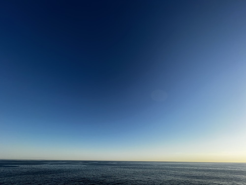 a large body of water sitting under a blue sky