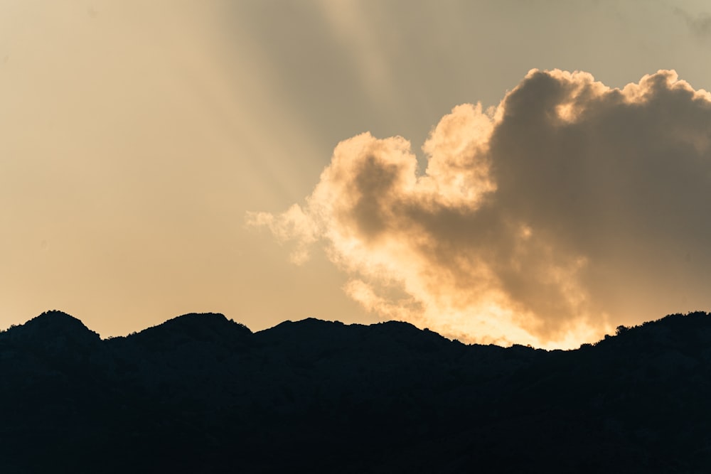 a bird flying in the sky over a mountain